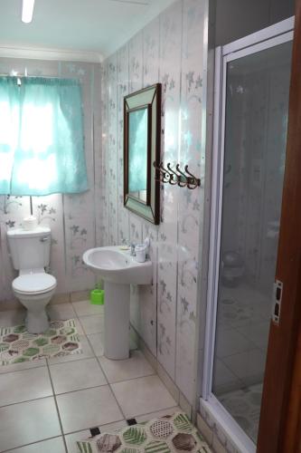 a bathroom with a toilet and a sink and a shower at Anerley Garden Park Resort in Port Shepstone