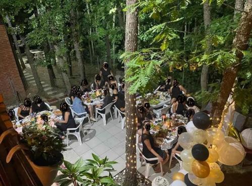a group of people sitting at tables in a garden at Cozy 3 bedroom mountain villa with scenic views in Novoberdo