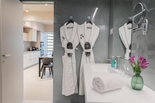 La salle de bains est pourvue de serviettes blanches accrochées au mur. dans l'établissement The Dome Aparthotel, à Satu Mare