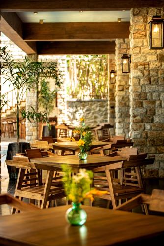 Un restaurante con mesas y sillas de madera y una pared de ladrillos. en The Rockwall Boutique Hotel Bentota, en Bentota