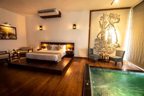 une chambre d'hôtel avec un lit et une piscine dans l'établissement The Rockwall Boutique Hotel, à Bentota