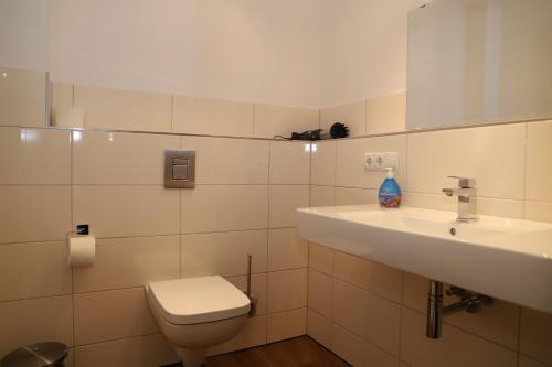 bagno bianco con lavandino e servizi igienici di Ferienwohnung1 in der Villa Westwind a Thiessow