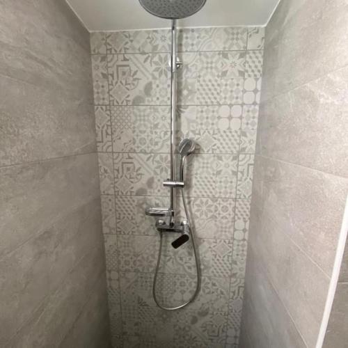 a shower with a shower head in a bathroom at Villa 4 étoiles SAINT LEU - Dodoterla in Saint-Leu