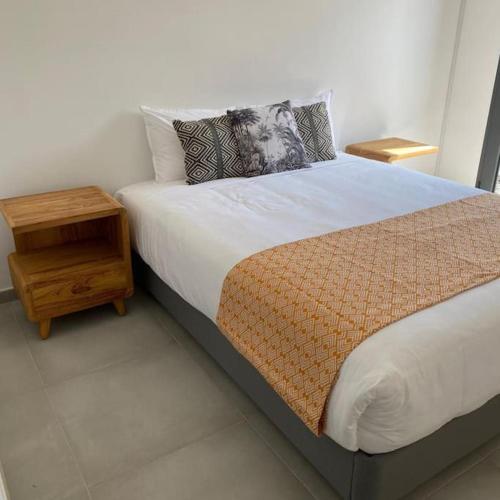 a bedroom with a bed with a nightstand next to it at Villa 4 étoiles SAINT LEU - Dodoterla in Saint-Leu