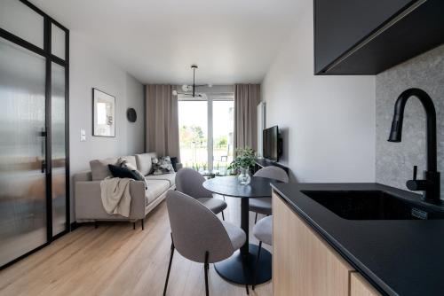 cocina y sala de estar con mesa y sofá en A Morze Las - apartament na Wyspie Sobieszewskiej en Gdansk