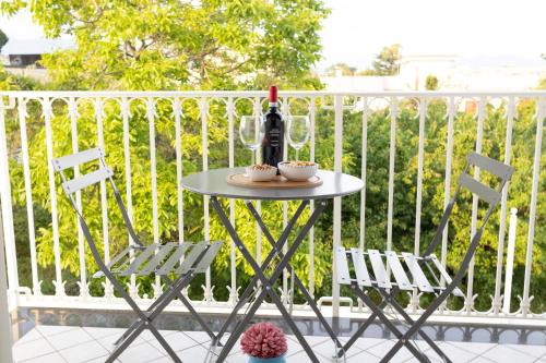 a table with two chairs and a bottle of wine at Rosy's House in Scafati