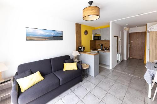 un salon avec un canapé et une cuisine dans l'établissement ~Joli studio à 100 m de la plage, à Les Sables-dʼOlonne