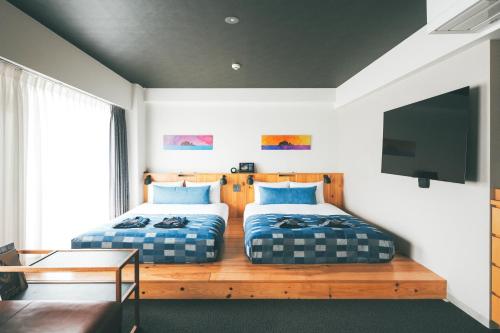 1 dormitorio con 2 camas y TV de pantalla plana en Anchor Hotel Fukuyama en Fukuyama