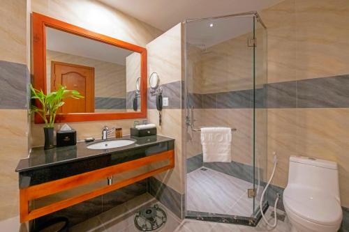 a bathroom with a shower and a toilet and a sink at Poulo Wai Hotel & Apartment in Phnom Penh