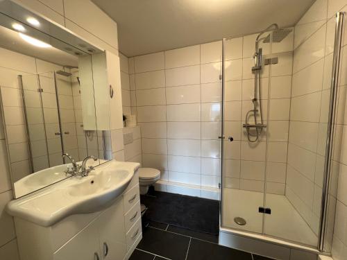 a bathroom with a sink and a shower and a toilet at Central Stadion Apartment by GG Rental Hamburg in Hamburg