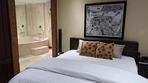 ein Schlafzimmer mit einem Bett und ein Badezimmer mit einer Badewanne in der Unterkunft Slipi Apartment 2BR in Jakarta