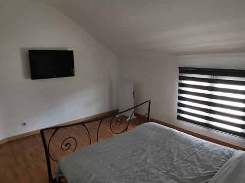 une chambre avec un lit et une télévision à écran plat dans l'établissement Gite en collocation le DIX, à Autry-le-Châtel