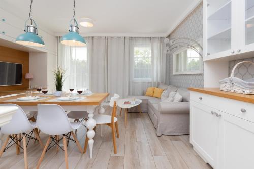 uma cozinha e sala de estar com mesa e cadeiras em Italian-style Apartment in the "Tesoro Gardens" by Renters em Gdynia