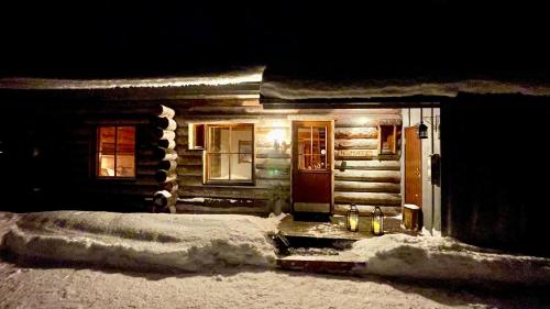 a log cabin with snow in front of it at Nilimukka log cabin near Levi center in Levi