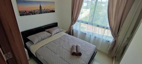 a pair of shoes sitting on a bed next to a window at Arcadia beach resort in Pattaya South