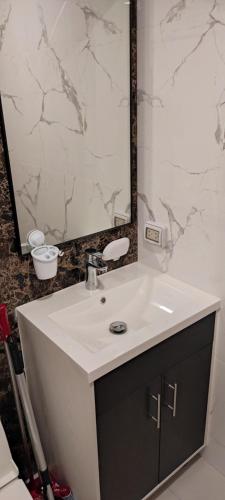 a bathroom with a white sink and a mirror at Arcadia beach resort in Pattaya South