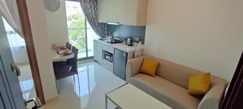 a small living room with a couch and a kitchen at Arcadia beach resort in Pattaya South