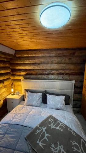 a bedroom with a bed in a wooden wall at Nilimukka log cabin near Levi center in Levi