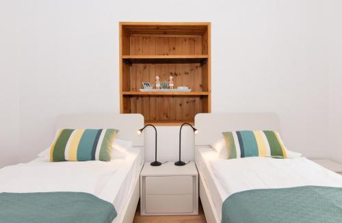 two beds sitting next to each other in a room at Walls of Piran Apartments and Rooms in Piran