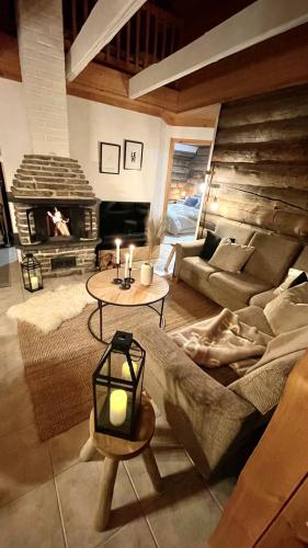 a living room with a couch and a fireplace at Nilimukka log cabin near Levi center in Levi