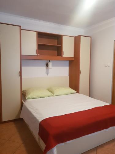 um quarto com uma cama com aabinet por cima em Apartments by the Sea em Lopar