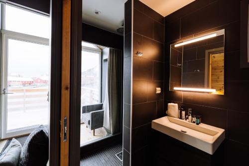 a bathroom with a sink and a mirror and a window at Solsiden Brygge Rorbuer in Ballstad