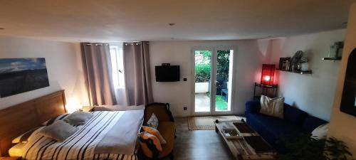 - une chambre avec un lit et un canapé bleu dans l'établissement Appartement Arles 35 m2, à Arles