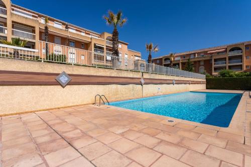 une piscine devant un immeuble dans l'établissement La Castillane - Appt avec piscine partagée, à Cavalaire-sur-Mer