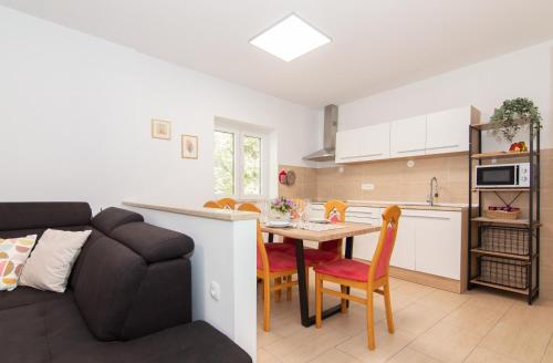 a kitchen and a living room with a couch and a table at Walls of Piran Apartments and Rooms in Piran