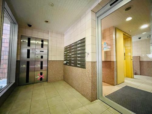 uma casa de banho com uma cabina de duche ao nível do chão e uma porta de vidro em 5-1観光スポット【大通公園】徒歩1分のサービスアパートメントSAPPORO大通西 em Ōdōri