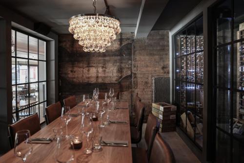 a dining room with a long table and a chandelier at Solsiden Brygge Rorbuer in Ballstad