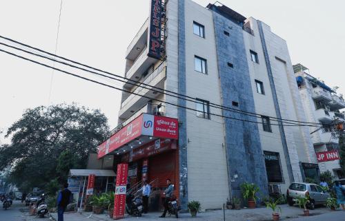 ein Gebäude an der Ecke einer Straße mit draußen stehenden Leuten in der Unterkunft Hotel J P Inn Near Patel Nagar Metro Station in Neu-Delhi