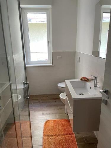 a bathroom with a toilet and a sink and a window at Casa Vacanze Viola in San Benedetto del Tronto