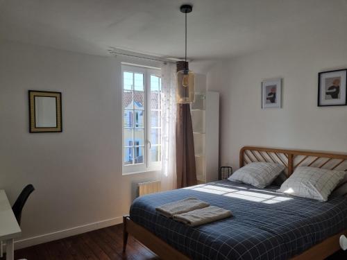 1 dormitorio con cama y ventana en Gîte Mhome Dieppe, en Dieppe