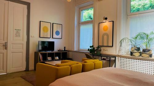 a bedroom with a bed and two yellow chairs at Fifteen Boutique Rooms Budapest with Self Check-In in Budapest