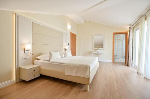 una camera bianca con un grande letto e una grande finestra di Luxury Apartments Villa Tunera a Porat