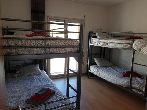 Zimmer mit 3 Etagenbetten und einem Fenster in der Unterkunft Bela Baia 2 in Salir de Porto