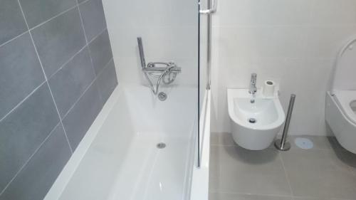 Un baño blanco con inodoro y lavabo. en Bela Baia 2, en Salir de Porto