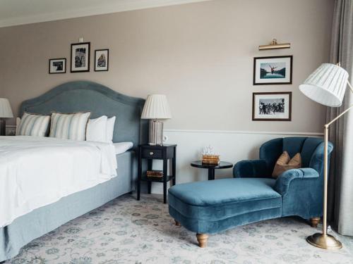 1 dormitorio con 1 cama y 1 silla azul en Marienlyst Strandhotel, en Helsingør