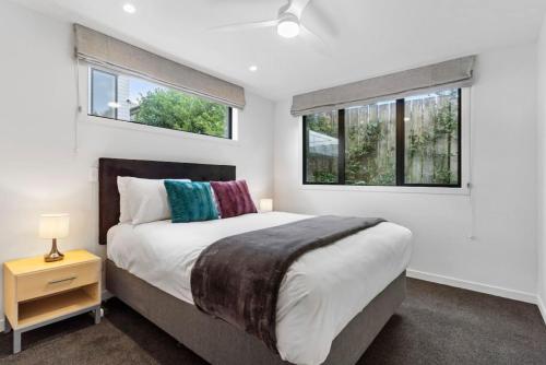 a bedroom with a large bed and two windows at Amazing Western Springs position in Auckland