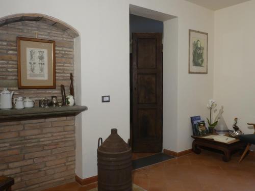 a living room with a brick fireplace and a wooden door at Helichrysum in Vinci