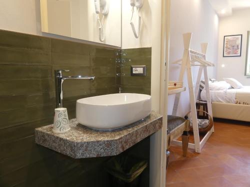 ein Badezimmer mit einem großen weißen Waschbecken auf der Theke in der Unterkunft Helichrysum in Vinci