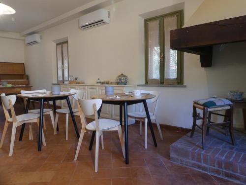 ein Esszimmer mit 2 Tischen und weißen Stühlen in der Unterkunft Helichrysum in Vinci