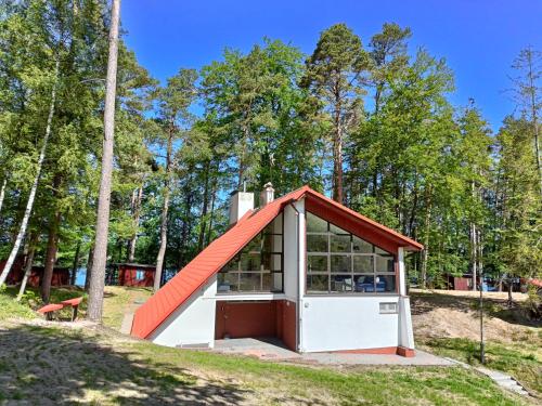a small shed with an orange roof in a field at Instytut Wypoczynku in Sulęczyno