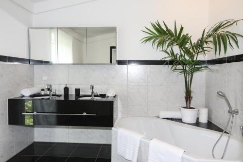 a bathroom with a tub and a sink and a mirror at ~ Regensburg schönstes Appartment~ in Sinzing