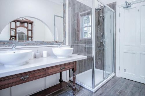 La salle de bains est pourvue de 2 lavabos et d'une douche. dans l'établissement Pendine Manor - 9 Bedroom Manor House - Pendine, à Pendine