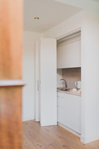 a kitchen with white cabinets and a sink at Relais Corte Guastalla Apartments in Sona