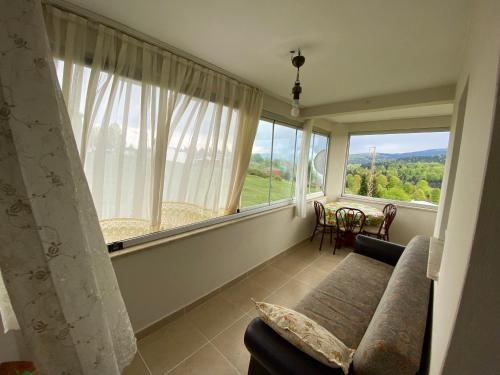 ein Wohnzimmer mit einem Sofa und einem großen Fenster in der Unterkunft Hıdırnebimountainhome in Akcaabat