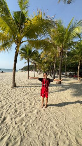 a young girl standing on a beach with palm trees at NHÀ NGHỈ VIỆT NGA in Ha Tien