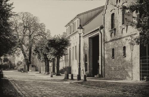 a black and white photo of a street next to a building at Hotel Zur Linde Dein Self Check In in Michendorf